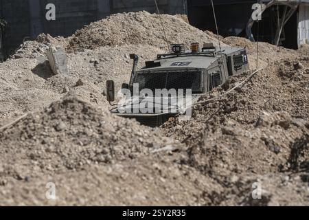 Tulkarm, Palestina. 26 febbraio 2025. Un veicolo militare israeliano pattuglia le strade del campo profughi distrutto di Nur Shams. Le forze israeliane hanno permesso ai residenti di recuperare i loro effetti personali dopo aver emesso avvisi di demolizione per diverse case, nel mezzo di un assalto di settimane in Cisgiordania che ha allontanato circa 30.000 palestinesi dalle loro case all'interno del campo profughi di Nur Shams. Credito: SOPA Images Limited/Alamy Live News Foto Stock