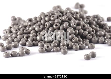 Primo piano di perline grigie su sfondo bianco. Sfondo o trama delle perline. Macro, viene utilizzato per rifinire gli abiti alla moda. crea collana con perline o. Foto Stock