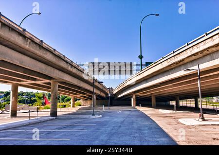 Superstrada con un grande cavalcavia e un cartello con la scritta "nessun parcheggio". Il cielo è limpido e il sole splende Foto Stock