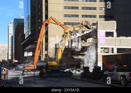 Ottawa, Canada - 26 febbraio 2024: Le gru lavorano per rimuovere neve e detriti da un garage multilivello in Slater Street, nel centro città. Una parte del garage è crollata la mattina presto, inviando mucchi di neve e cemento giù per tre livelli a terra e danneggiando diversi veicoli. La causa non è ancora stata determinata, ma potrebbe essere dovuta all'elevato livello di neve che non era ancora stato eliminato. La città ha ricevuto 70 centimetri di neve tra il 12 febbraio e il 16 febbraio. Foto Stock
