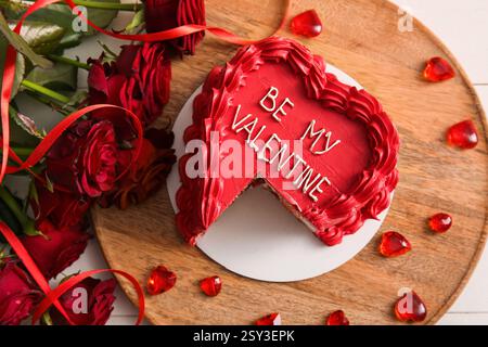 Piatto con dolce bento tagliato e splendide rose rosse su sfondo bianco in legno. Festa di San Valentino Foto Stock