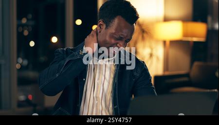 Uomo nero, collo e dolore in ufficio di notte con stress per straordinari, burnout e tensione muscolare da postura cattiva. Africano, dipendente e si allunga per Foto Stock
