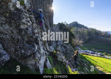 Due arrampicatrici che scalano una scogliera, godendosi una giornata di sole in un pittoresco ambiente naturale Foto Stock