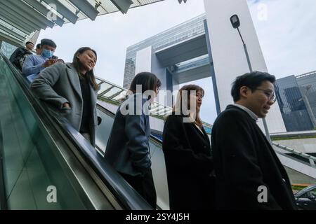 Hong Kong, Cina.26 febbraio 2025. La gente scende da una scala mobile presso gli uffici del governo centrale di Hong Kong il 26 febbraio 2025 a Hong Kong, Cina. Il segretario finanziario di Hong Kong Paul Chan Mo-po ha dichiarato che entro aprile 2027 ci saranno 10.000 licenziamenti dei funzionari pubblici. Crediti: Chen Yongnuo/China News Service/Alamy Live News Foto Stock