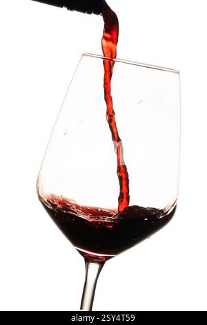 Vino rosso versato in un bicchiere di vino. movimento del liquido congelato su sfondo bianco Foto Stock