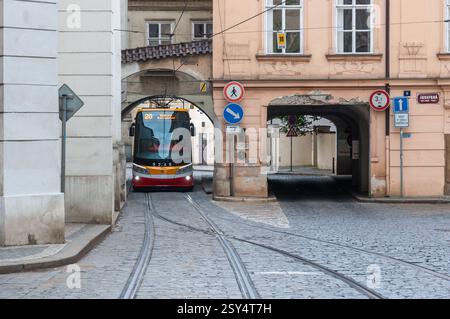 Praga, Repubblica Ceca - 12 giugno 2016: Un moderno tram passa attraverso una stretta arcata nel quartiere storico, che mostra la miscela di Foto Stock