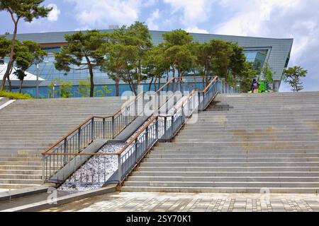 Sejong City, Corea del Sud - 26 maggio 2021: Una grande scalinata con rampe incorporate conduce al Government Sejong Convention Center, circondato da Pine tre Foto Stock