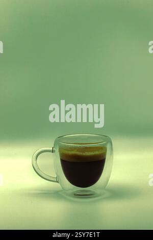 Un espresso doppio, isolato in una tazza di caffè trasparente. Foto Stock
