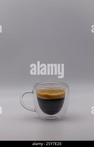 Un espresso doppio, isolato in una tazza di caffè trasparente. Foto Stock