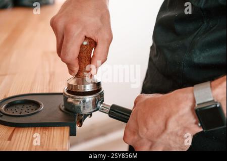 Preparazione del caffè con l'attrezzo speciale. Barista al bar. Vista ravvicinata. Foto Stock