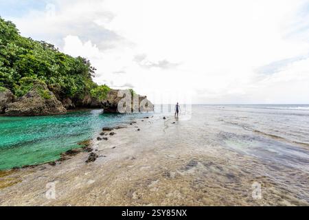 Splendida vista sulla spiaggia presso la piscina e gli appartamenti di roccia Magpupungko a Siargao, Filippine, una popolare destinazione turistica conosciuta per le piscine di marea e la bellezza paesaggistica Foto Stock