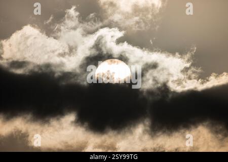 Il sole mattutino brucia attraverso spessi strati di nebbia. Foto Stock