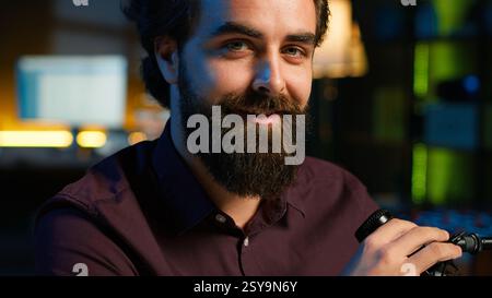 Ritratto di un influencer sorridente in home studio che esegue trasmissioni live per piattaforme di streaming online, parlando con i fan. Jolly media star che racconta agli spettatori fatti su se stesso, cita Un primo piano Foto Stock