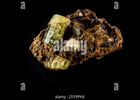 Rock di colore giallastro e marrone è visualizzato su uno sfondo nero. La roccia è composta da vari minerali e ha una consistenza ruvida. È un Foto Stock
