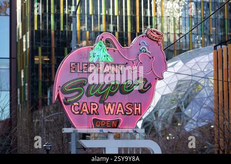 Il cartello Elephant Car Wash, un amato punto di riferimento locale, è annidato tra gli edifici del quartier generale Amazon presso la torre Amazon Nitro South nel Triangolo Denny di Seattle Foto Stock
