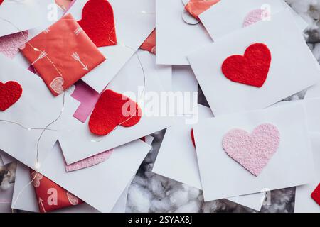 Buste di San Valentino adornate da cuori in feltro rosso e rosa, disseminate elegantemente tra le luci delle fate. Una scena perfetta che cattura l'amore e l'affetto. Foto Stock