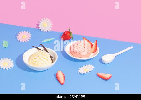 Due ciotole di gelato, vaniglia e fragole, disposte su un vivace sfondo rosa e blu, accessoriate con fragole fresche e farina decorativa Foto Stock