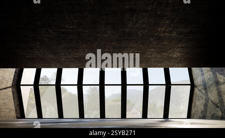 Grandi finestre geometriche incorniciano una vista panoramica, con luce naturale che illumina le pareti e il soffitto in cemento, mettendo in risalto un'architettura moderna Foto Stock