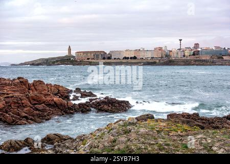 Baia della spiaggia di Riazor nella città spagnola di Un Coruña e il faro della torre di Ercole sullo sfondo Foto Stock