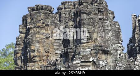 Immagine panoramica delle gigantesche facce scolpite in pietra del Bodhisattva Lokeshvara, noto anche come Avalokiteshvara, Tempio di Bayon, Angkor Thom, UNESCO World Heri Foto Stock