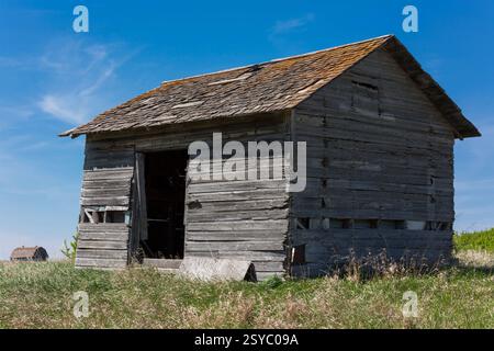 Piccolo, vecchio edificio in legno con tetto inclinato. Il tetto è coperto di muschio Foto Stock