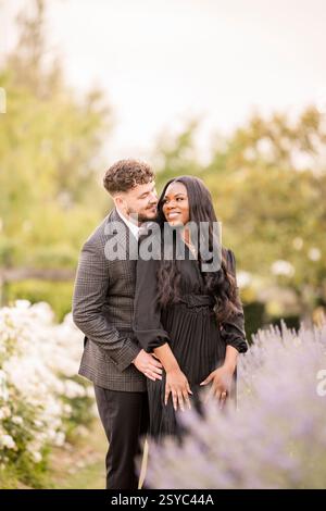 Coppia che condivide un momento d'amore in un bellissimo giardino Foto Stock