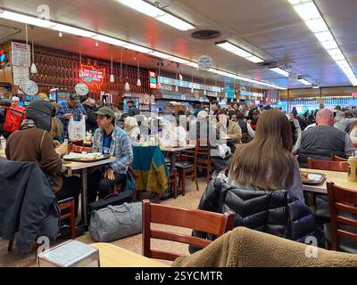 Innenraum von Katz's Delicatessen a New York. Der Tisch von Meg Ryan und Tom Hanks wird durch ein an der Decke baumelndem Schild angezeigt. Foto Stock