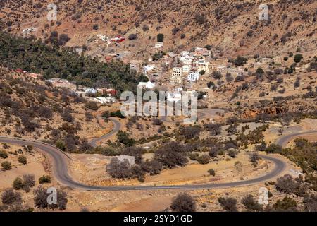 Una piccola strada di passaggio con vedute panoramiche dei tradizionali villaggi berberi si snoda attraverso le montagne dell'alto Atlante vicino a Timkit, Souss-massa, Marocco. Foto Stock