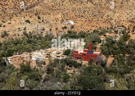 Una piccola strada di passaggio con vedute panoramiche dei tradizionali villaggi berberi si snoda attraverso le montagne dell'alto Atlante vicino a Timkit, Souss-massa, Marocco. Foto Stock