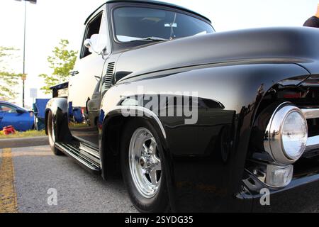 Primo piano di un camion nero vintage restaurato con dettagli cromati e ruote scintillanti in mostra, che mostrano il classico design e la maestria artigianale americana Foto Stock