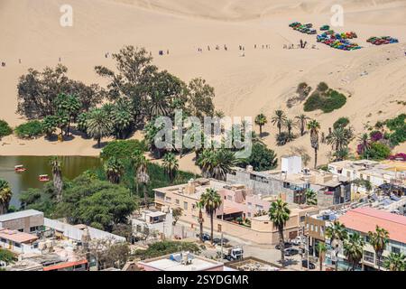 L'iconica oasi di Huacachina a Ica in Perù presenta una laguna tranquilla dune dorate e lussureggianti palme Foto Stock