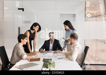 Diversi gruppi di lavoratori multietnici si riuniscono per tavolo per una conversazione informale Foto Stock