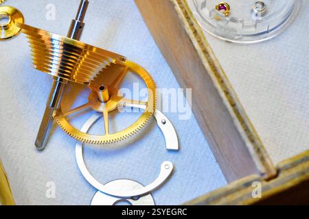 I complessi componenti dell'orologio rivelano l'arte della progettazione meccanica in un'accattivante ambientazione dell'officina Foto Stock