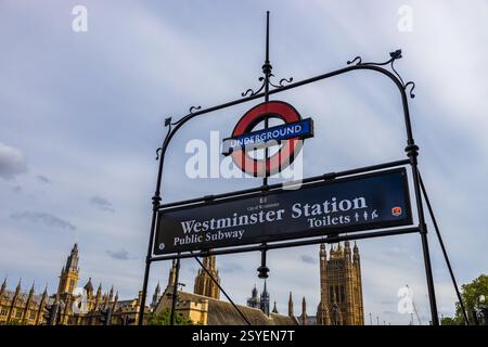 Stazione di Westminster, insegna della metropolitana di Londra con Houses of Parliament sullo sfondo Foto Stock