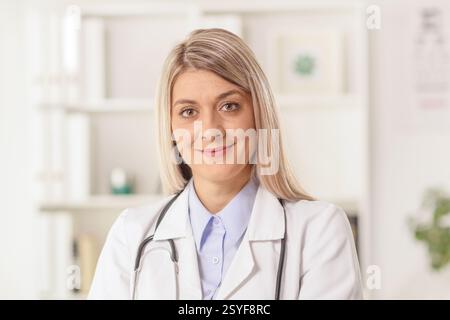 Giovane dottoressa seduta in un ufficio Foto Stock