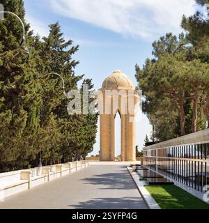 Baku, Azerbaigian - 6 maggio 2024: La corsia dei martiri onora i soldati caduti nel conflitto del Nagorno-Karabakh. Presenta tombe dei soldati e un monumento centrale, un'imponente torre di pietra con una fiamma eterna Foto Stock