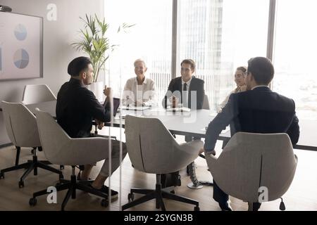 Leader fiducioso di uomini d'affari diversi imprenditori discutono del progetto nella sala riunioni Foto Stock