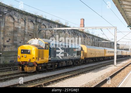 Locomotiva diesel classe 37 costruita negli anni '1960, 37402 Oor Wullie con un treno di manutenzione Network Rail nella stazione di Carlisle, Cumbria, Inghilterra, Regno Unito Foto Stock