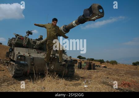 GALILEA SETTENTRIONALE - ISRAELE, 15 LUGLIO 2006. Un soldato israeliano salta da un'artiglieria semovente M109 da 155 mm torretta durante la guerra israeliana con Hezbollah Foto Stock