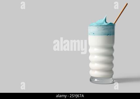 Bicchiere di dalgona blu matcha latte con paglia su sfondo bianco Foto Stock