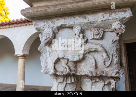 Un primo piano di un'intricata capitale in pietra intagliata, con una creatura mitica e altri motivi decorativi Foto Stock