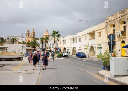 Marsaxlokk, il centro di Malta e i turisti che camminano intorno Foto Stock