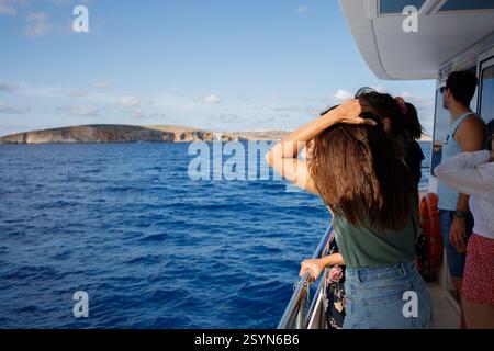 Vista sull'isola di Comino, Malta da una barca turistica con turisti Foto Stock
