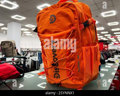 Kiev, Ucraina - 27 febbraio 2025: Uno zaino Discovery Tundra 23 arancione in mostra su uno stand in un negozio illuminato Foto Stock