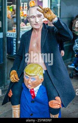 Un personaggio di Vladamir Putin viene portato sulle spalle di un burattino di Donald Trump in una protesta a Londra. Foto Stock