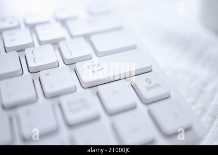 Mani di una donna d'affari che preme il tasto Invio sulla tastiera del computer Foto Stock