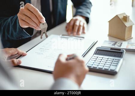 Gli uomini d'affari firmano un contratto stipulando un accordo con il concetto di agente immobiliare per consulente e concetto di assicurazione domestica. Foto Stock