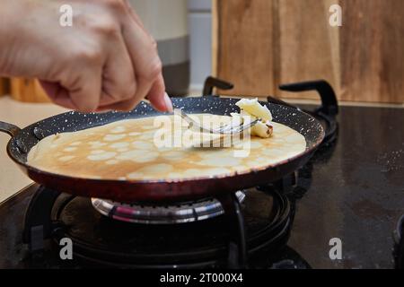 Cuocere le frittelle di Crepe Suzette in padella su un piano cottura a gas. Riscalda i pancake con il burro. Foto Stock