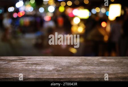 Tavolo vuoto di legno scuro davanti allo sfondo astratto di bokeh sfocato del ristorante. può essere utilizzato per la visualizzazione o il montaggio del pr Foto Stock