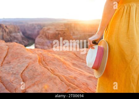 Bella donna in abito giallo sul bordo della scogliera dell'Horseshoe Band Canyon a Paje, Arizona. Splendida natura negli Stati Uniti Foto Stock